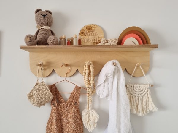 Scalloped peg shelf with neutral toned handmade nursery decor pieces